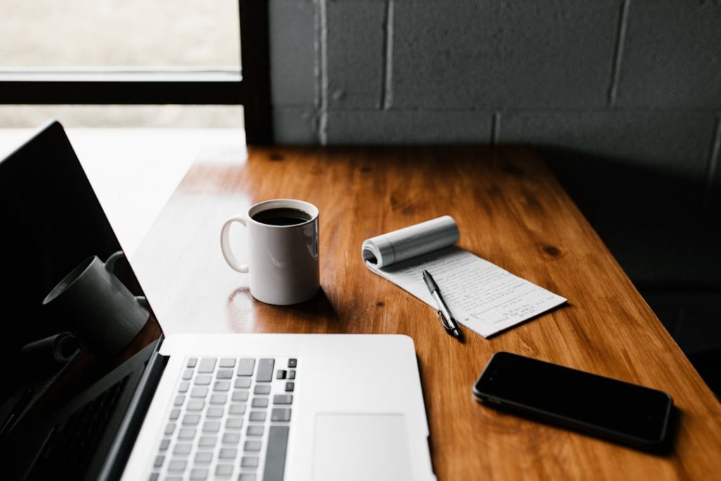 Content writing workspace with laptop and notepad representing AI content optimization tools.