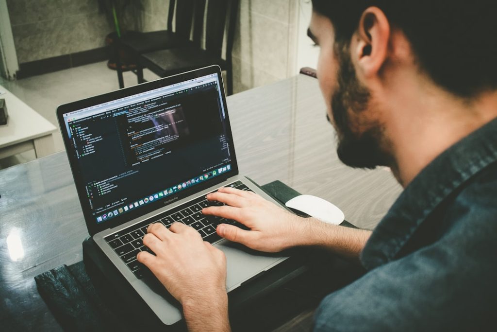 Developer reviewing code on a laptop representing technical SEO auditing and site crawl analysis.